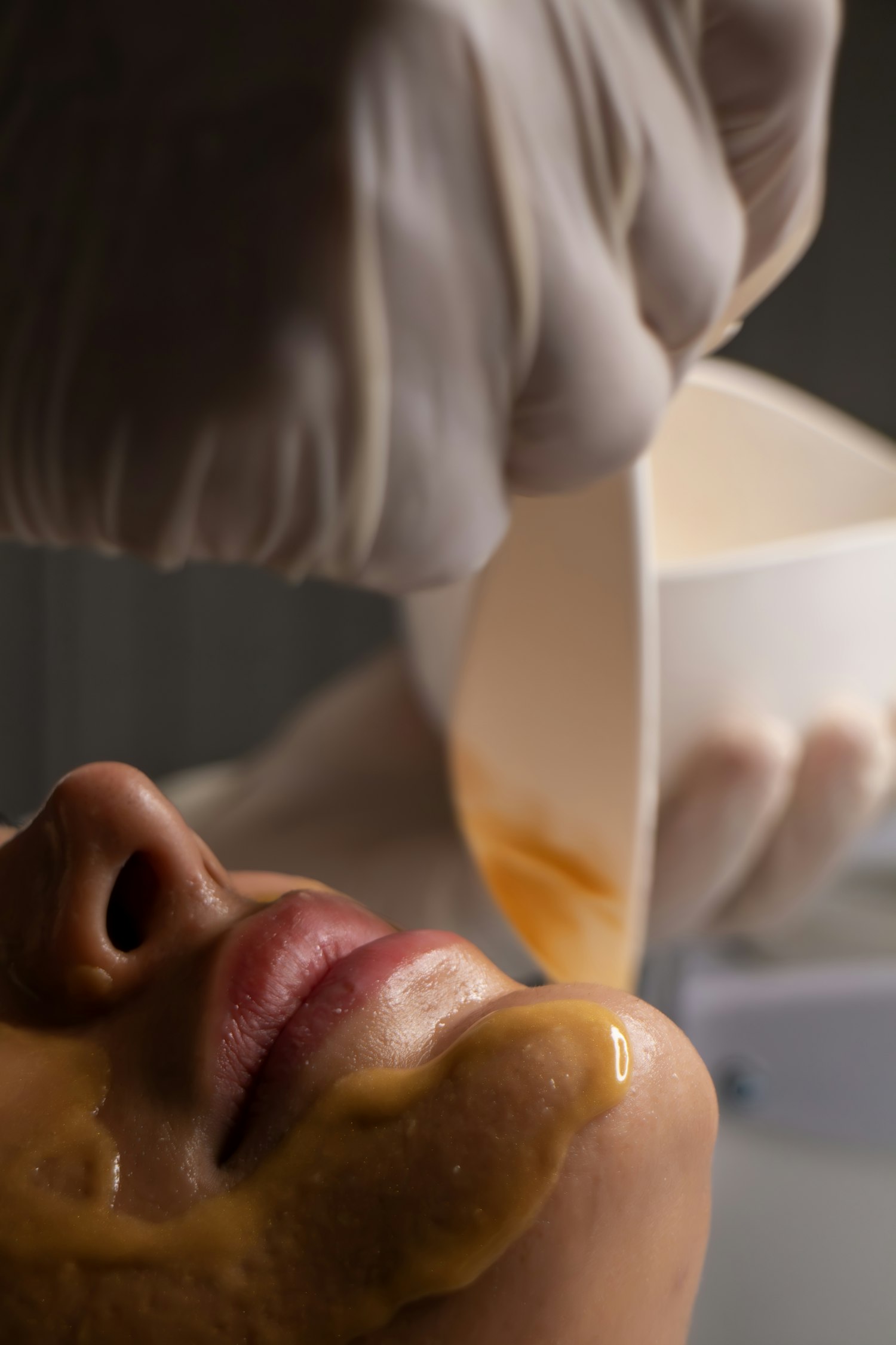 Esthetician performing a facial treatment on a reclined client
