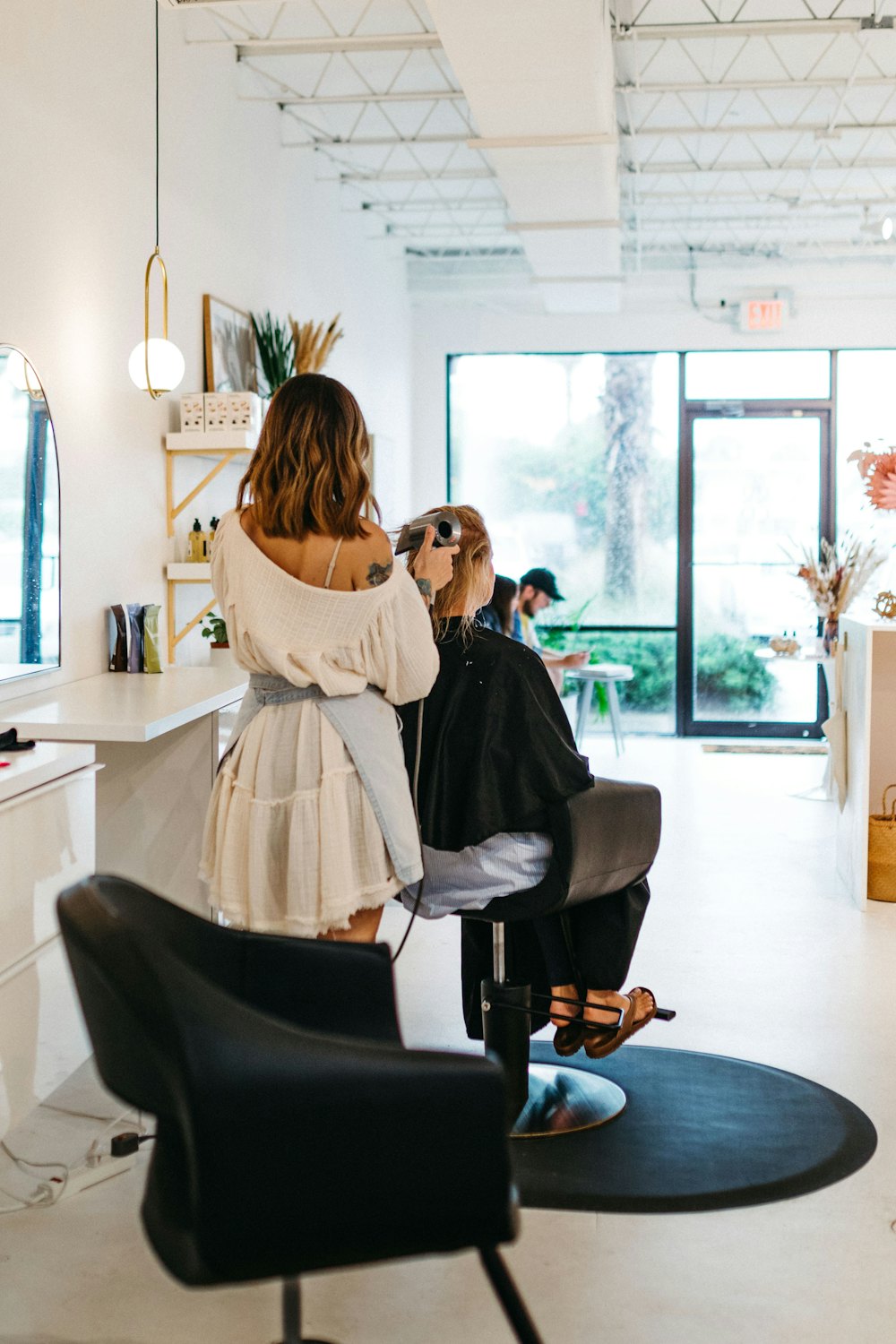 Stylist blow-drying a fresh balayage at the chair