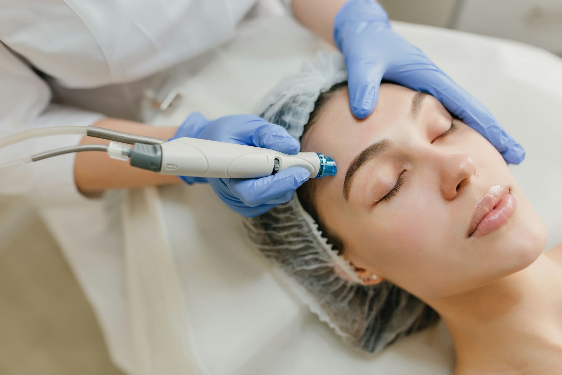 Practitioner preparing a client for a skincare treatment in a modern treatment room