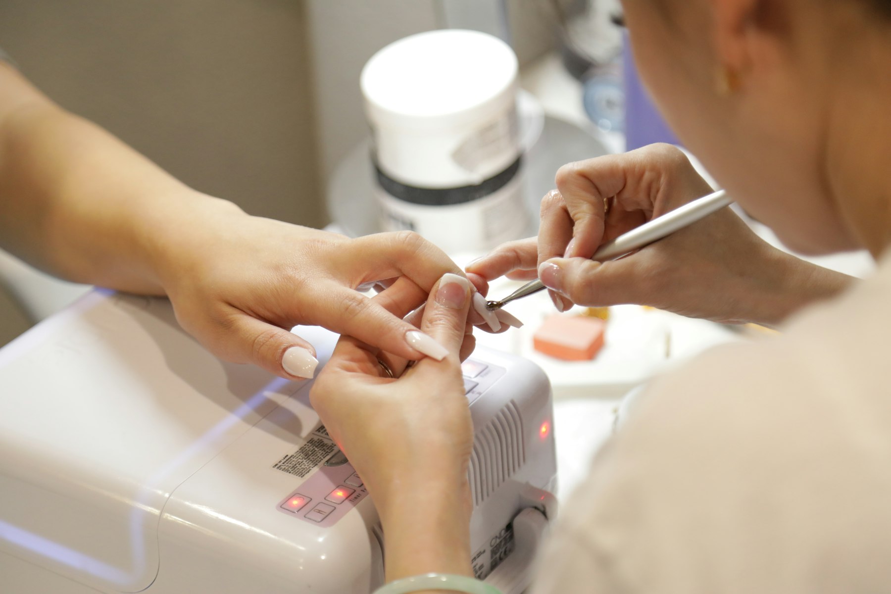Nail technician finishing a detailed manicure